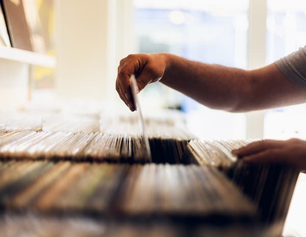 Hænder der bladrer gennem en kasse med vinylplader